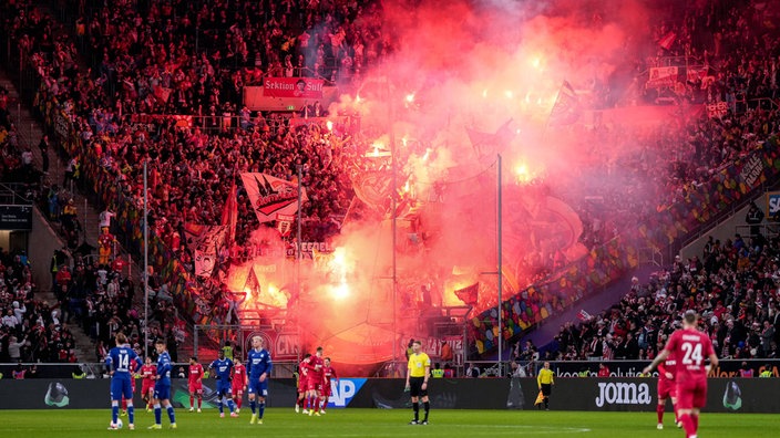 Die Fans vom 1. FC Köln zünden beim Spiel gegen Hoffenheim in der Fankurve Pyrotechnik.