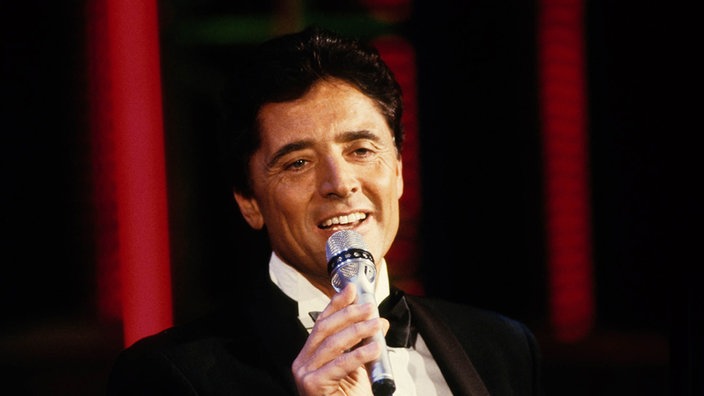 Sacha Distel singend mit Mikrofon