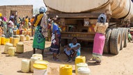 Menschen in Kenia mit Kanistern an Wasser-Tankwagen / 2013