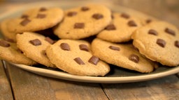 Viele runde Schoko-Cookies liegen schön serviert auf einem Teller.