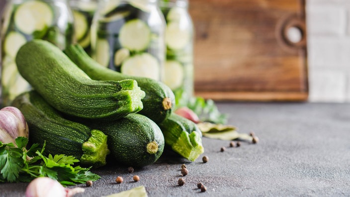 Zucchinis liegen Knoblauch und Pfeffer auf dem Tisch. 