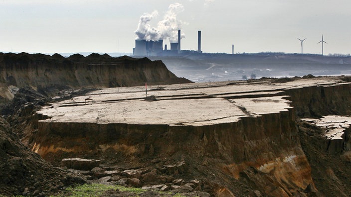 Blick auf Erdmassen vor Braunkohlkraftwerk