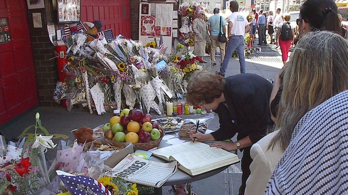 Eine Frau trägt sich vor eine Feuerwache in New York in ein Kondolenzbuch ein