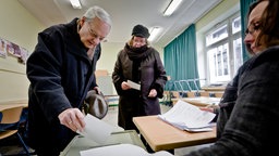 Waehler fuellen am Sonntag (12.02.12) in einem Wahllokal in Duisburg ihre Stimmzettel zur Abstimmung ueber die Abwahl des Oberbuergermeisters von Duisburg, Adolf Sauerland (CDU), in Wahlkabinen aus