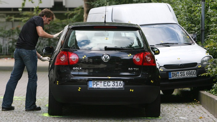 Ermittler untersucht ein Fahrzeug am Tatort