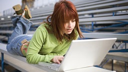 Junge Frau benutzt Notebook unterwegs