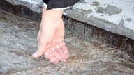 Hand, die ins Wasser gehalten wird