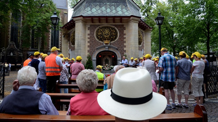 Pilger sitzen vor der Marienkapelle in Kevelaer | Bildquelle: dpa Pilger sitzen vor der Marienkapelle in Kevelaer