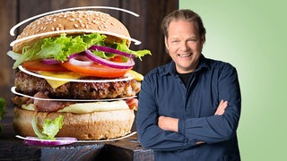 Björn Freitag lächelt in die Kamera. Links neben ihm ist ein klassicher Hamburger abgebildet.