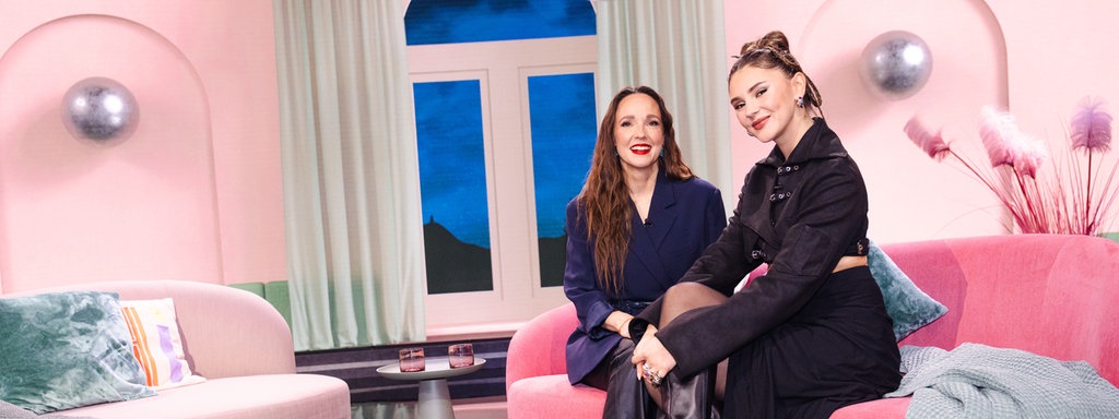 Carolin Kebekus sitzt gemeinsam mit Stefanie Giesinger auf der Couch. Beide lächeln in die Kamera.