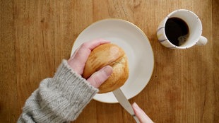 Ein Brötchen wird auf Teller aufgeschnitten.