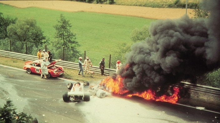 Ein Autounfall auf einer Rennstrecke mit brennendem Wagen