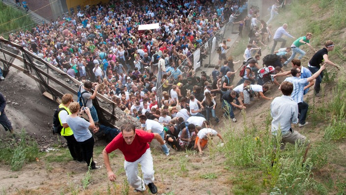 Festivalbesucher Böschung hoch laufend, Aufsicht.