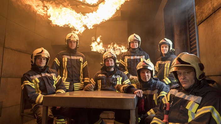 Feuerwehrmänner vor einer brennenden Wand