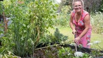 Kai Judith Wetzel steht an einem Hochbeet mit Salat. 