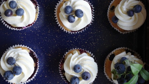 Blaubeer-Cupcakes mit Zitronen-Frosting auf einer Platte