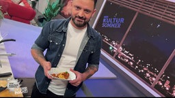 Alexander Wulf mit Currywurst und Chips auf einem Imbiss-Porzellanteller