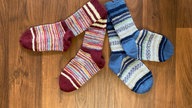 Gestrickte Socken auf braunem Grund