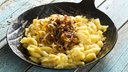 Spätzle mit gerösteten Zwiebeln in einer Pfanne