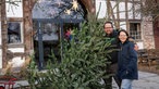 Anja Pötting mit ihrem Mann Marius und dem Weihnachtsbaum vor dem Haus.