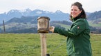 Theresa Tischner auf der Weide mit Bergpanorama im Hintergrund.