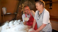 Frank Buchholz und Margarete Klemme abcken Brot. 