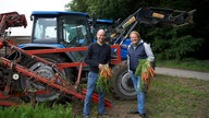 Björn Freitag mit Vitus Schulze Wethmar (li). vor dem Trecker.