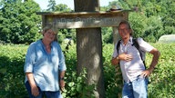 Frank Buchholz und Maren vor dem Schild "Dorfacker". 