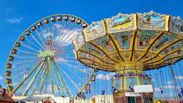 Ein Riesenrad auf der linken Seite und ein traditionelles Karussel auf der rechten Seite.