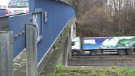 Ein Auto fährt über eine Autobahnbrücke und ein LKW darunter her. 