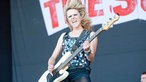 Bassistin von The Subways spielt und schüttelt ihr langes blondes Haar