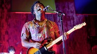 Frontmann von Bloc Party spielt Gitarre und singt mit zurückgeworfenem Kopf