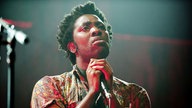 Bloc Party Sänger hält das Mikro mit beiden Händen fest und schaut nach oben.