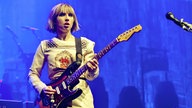 Frontfrau von "The Joy Formidable" spielt mit offenem Mund Gitarre im blauen Bühnenlicht.