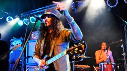 Rockmusiker, Musikproduzent und Plattenlabelchef Brant Bjork erhebt den Zeigefinger auf der Bühne