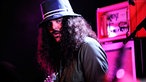 Brant Bjork trägt einen extravaganten Fischerhut, unter dem seine lange Mähen zum Vorschein tritt