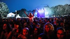 Die Fans warten vor der Bühne in der Dämmerung auf ihre Band