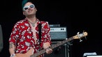 Bassist der Me First & The Gimme Gimmes spielt und blickt glücklich Richtung Publikum