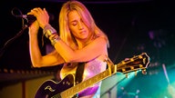 Heather Nova hält sich mit beiden Händen am Ständer des Mikrofons fest und neigt den Kopf mit geschlossenen Augen zu Seite