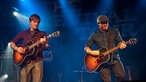 Zwei Gitarren spielende Musiker auf der Bühne