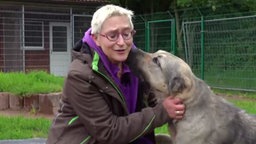 Eine Hunde-Expertin kuschelt mit einem Herdenschutzhund 