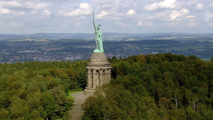 Luftaufnahme des Hermannsdenkmals - ein Rundbau mit einer riesigen grünen Ritterfigur