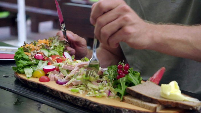 Holzplatte mit üppigem Wurstsalat