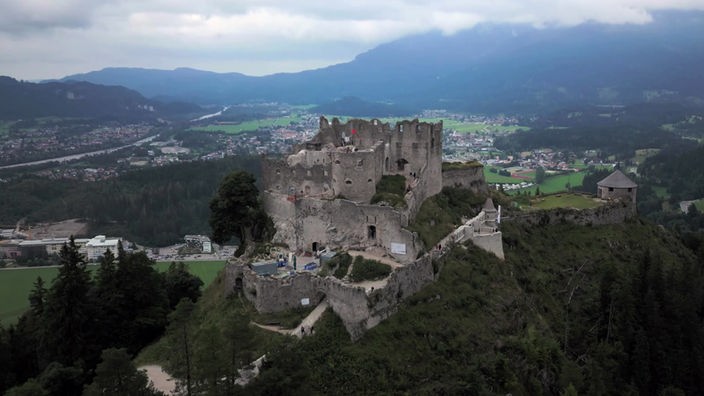 Luftaufnahme der Festungsruine auf einem Berg vor Alpenpanorama