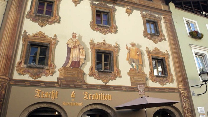 Mit Figuren und Ornamenten bemalte, mehrstöckige Hausfassade