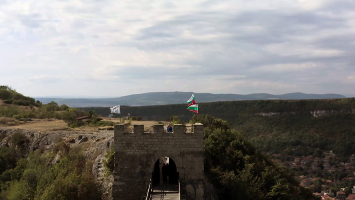 Blick über einen Steinturm in die weite Gebirgslandschaft