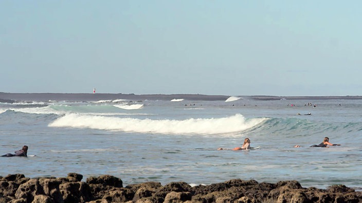 Surfer in den Wellen am Strand, hier am North Shore