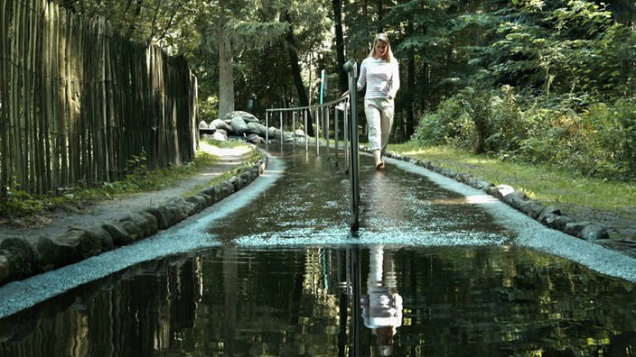 Judith Rakers wandelt barfuß durch einen Wasserlauf