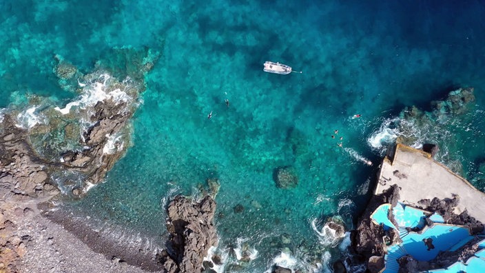 Blick von oben auf Bucht mit türkisfarbenem Wasser