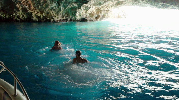 Zwei Badende im türkisfarbenen Wasser der Blauen Grotte